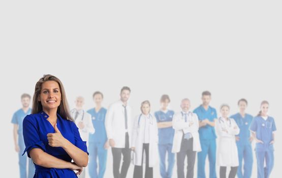 Happy female patient with thumb up and team of doctors isolated on gray background with copy space for text