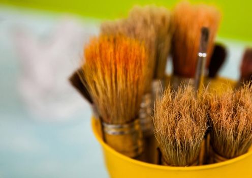 paint brushes in the glass with green natural background