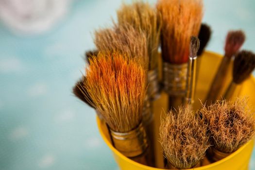 paint brushes in the glass with green natural background