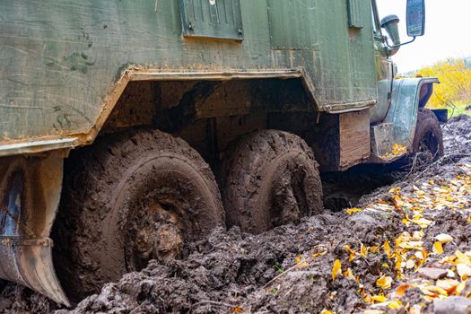 The truck got stuck on a dirty, broken forest road. Autumn thaw. Offroad.