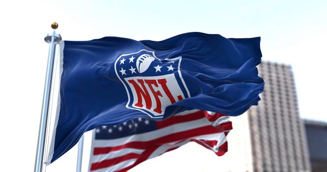 Inglewood, CA, USA, January 2022: The flag with the NFL logo waving in the wind with the US flag blurred in the background. The National Football League is a professional American football league