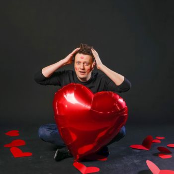 valentines red heart, balloon in hands, handsome gay. On a black background crazy event giving