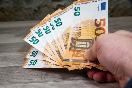 man hand holding 50 euro banknotes fan-shaped