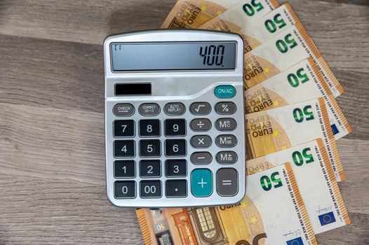 50 euro banknotes with calculator on wooden table