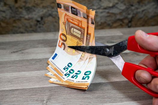 cut 50 banknotes with euro scissors on rough background