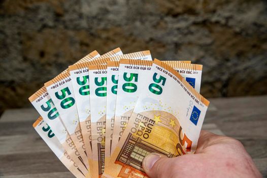 man hand holding 50 euro banknotes fan-shaped