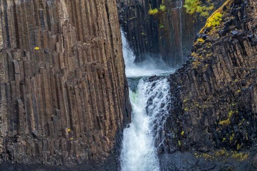 Closeup view of waterfall and basaltic rock walls