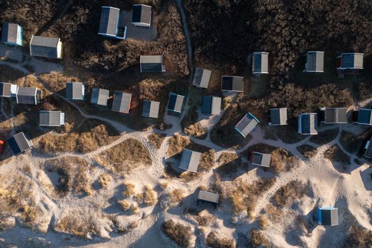 Tisvildeleje, Denmark - January 21, 2022: Aerial drone view of wooden beach huts in the sand dunes