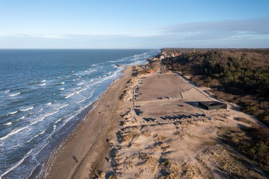 Tisvildeleje, Denmark - January 21, 2022: Aerial drone view of the coastline with the public parking lot at the beach.