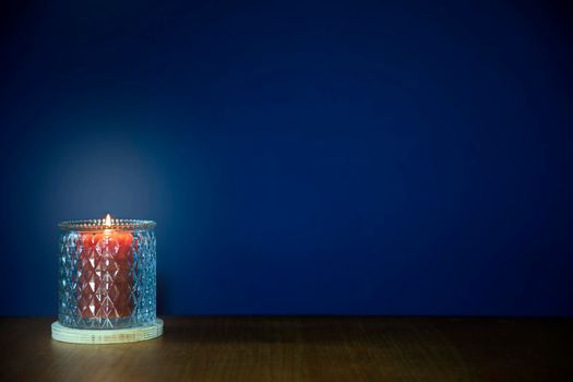 Burning candles on wooden table against dark blue background with copy space. stylish home decoration, space for text