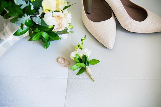 Wedding accessories: shoes, rings, boutonnieres perfume on a white background