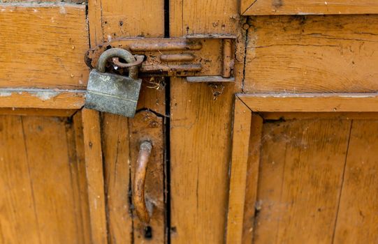 The old abandoned brown door is locked