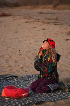 A young girl makes a wish on the first star at the beach. Her hands are in a praying pose. High quality photo