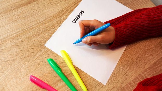 Woman writing down her dreams list by colored markers. Visualization of dreams