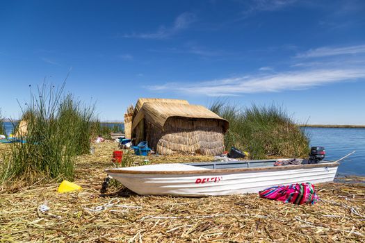 Titicaca Lake, Peru - October 14, 2015: Straw huts and a boat on one of the Titino Floating Islands on the Titicaca Lake.