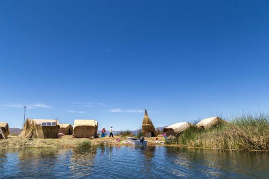 Titicaca Lake, Peru - October 14, 2015: Straw huts and boats on one of the Titino Floating Islands on the Titicaca Lake.