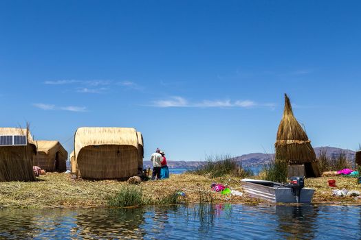 Titicaca Lake, Peru - October 14, 2015: Straw huts and boats on one of the Titino Floating Islands on the Titicaca Lake.