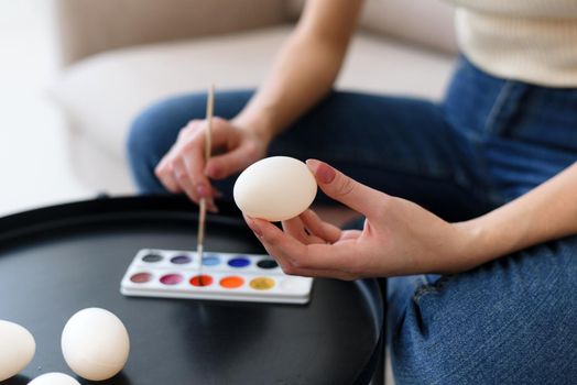 Easter, holiday concept - Young mother painting eggs for easter.