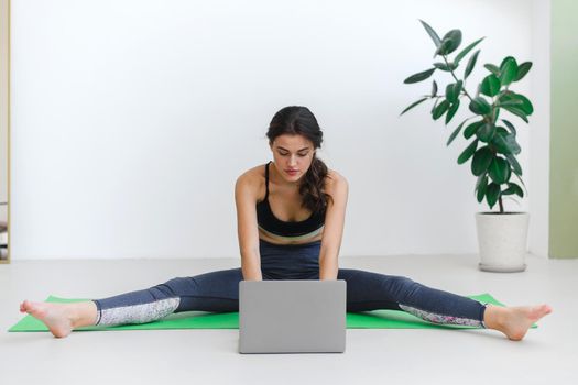 Young woman doing stretching, keeping fit during pandemic and quarantine