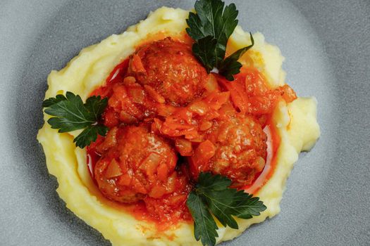 Meatballs in tomato sauce with mashed potato on the white plate, top view, view from above.