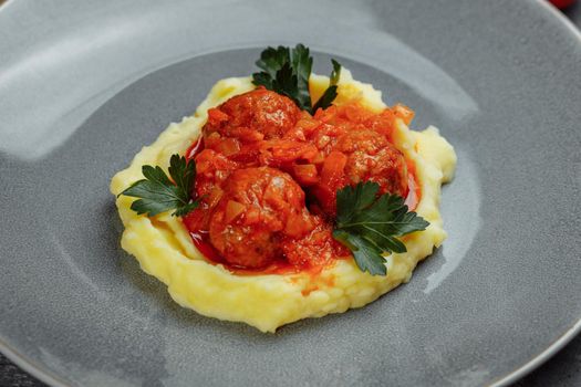 Meatballs in tomato sauce with mashed potato on the white plate, top view, view from above.