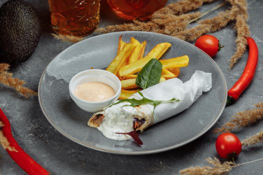 Shawarma Sandwich with French Fires and Salt Grinder on Dark Background.