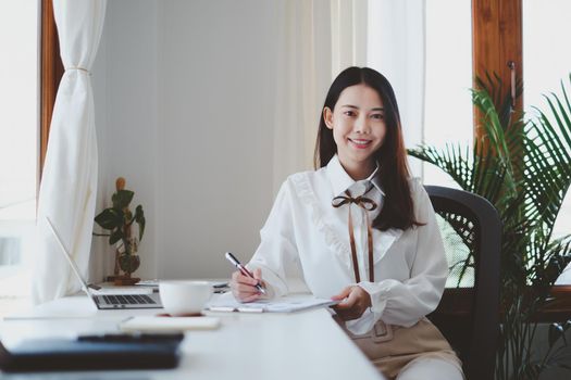 Asian Businesswoman or Accountant hands holding paperwork with calculator, account and saving concept