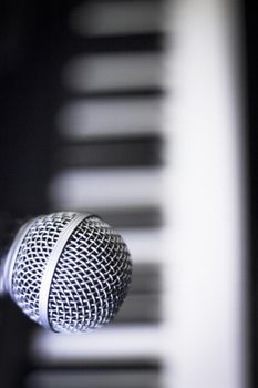 Microphone over piano keys in dim light. No people