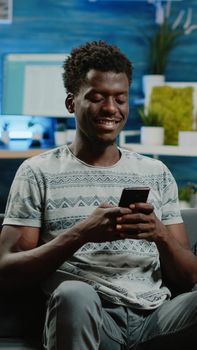 Adult holding smartphone for text messages on touch screen. Man using phone after remote work, texting on device. Freelancer using gadget for online communication and browsing internet