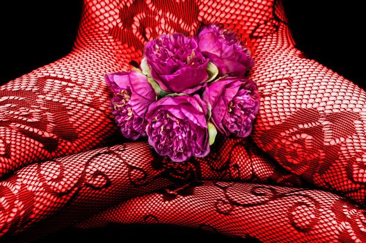 A woman in fishnet tights on her naked body sits cross-legged with pink peonies. Image in red on a dark background