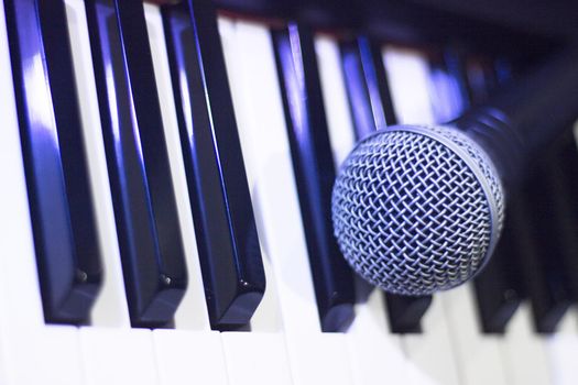 Microphone over piano keys in dim light. No people