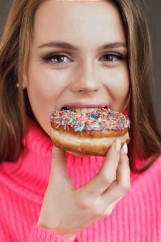 Young happy woman with donut smiling. High quality photo