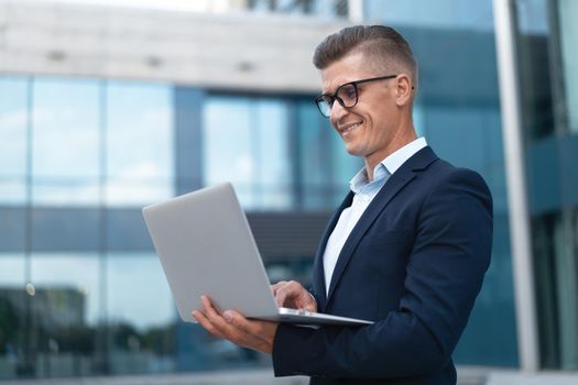 Business. Businessman Using Laptop Outdoor Adult Caucasian Male Business Person Eyeglasses Watching Notebook Screen Outside Smiling Happy Positive Emotions Background Big City Street