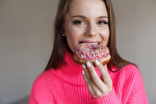 Young happy woman with donut smiling. High quality photo