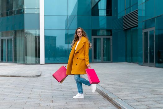 Business Woman With Shopping Bags Dressed Yellow Coat Walking Outdoors Corporative Building Background Caucasian Female Business Person Office Building Stylish Businesswoman Season Sale full length
