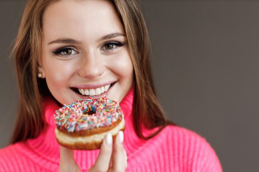 Young happy woman with donut smiling. High quality photo