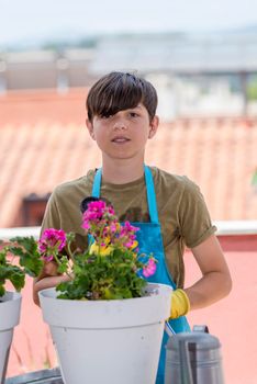 Portrait of a smiling teen holding plants on the terrace.