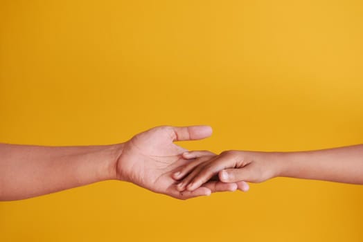 father holding his child boy hand on yellow background ,