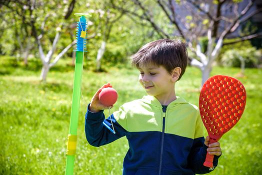 Happy boy is playing tetherball swing ball game in summer camping. Happy leisure healthy active time outdoors concept.