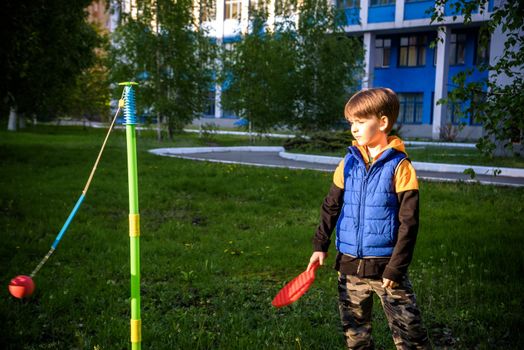 Happy boy is playing tetherball swing ball game in summer camping. Happy leisure healthy active time outdoors concept.