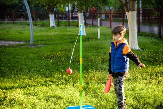 Happy boy is playing tetherball swing ball game in summer camping. Happy leisure healthy active time outdoors concept.