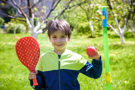 Happy boy is playing tetherball swing ball game in summer camping. Happy leisure healthy active time outdoors concept.