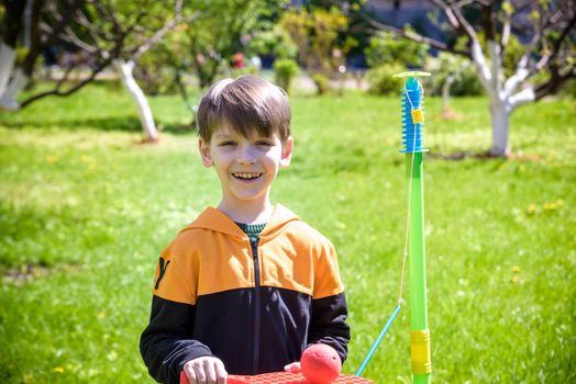 Happy boy is playing tetherball swing ball game in summer camping. Happy leisure healthy active time outdoors concept.