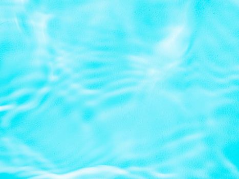 Ripple water texture on blue pool background. Shadow of water on sunlight. Mockup for product, spa or travel background. Marble blue water surface as wallpaper background
