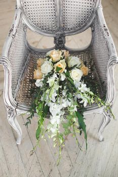 Wedding bouquet lying on a chair in a white Studio