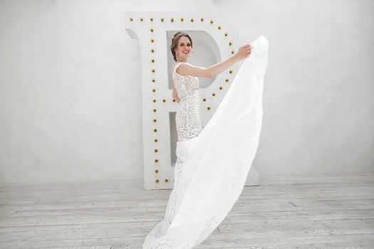 Beautiful bride posing in wedding dress in a white photo Studio.