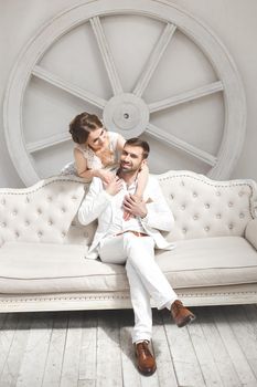 Chic wedding couple groom and bride posing in a white Studio.