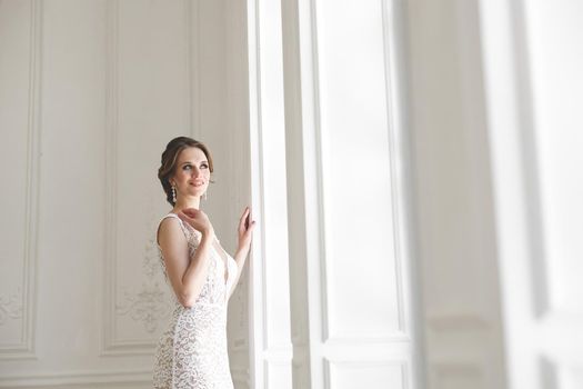 Beautiful bride posing in wedding dress in a white photo Studio.