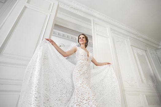 Beautiful bride posing in wedding dress in a white photo Studio.