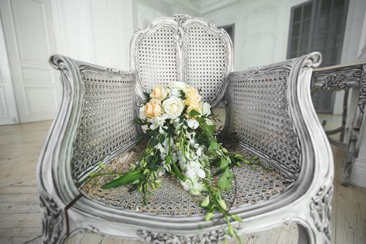 Wedding bouquet lying on a chair in a white Studio